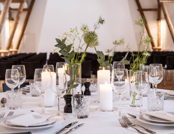 Elegant opdækning med blomster og glas i Stakladen