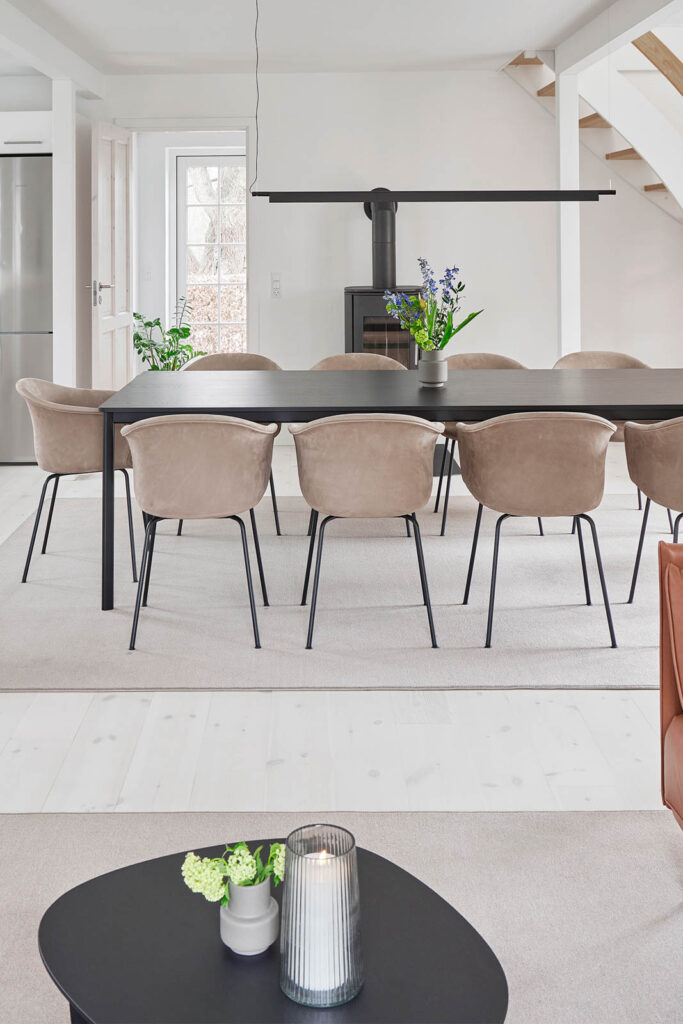 Spisebord med flere stole i lyst lokale