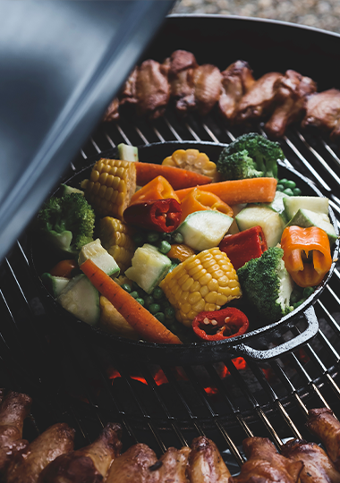 Grill med grøntsager og mad over åben ild